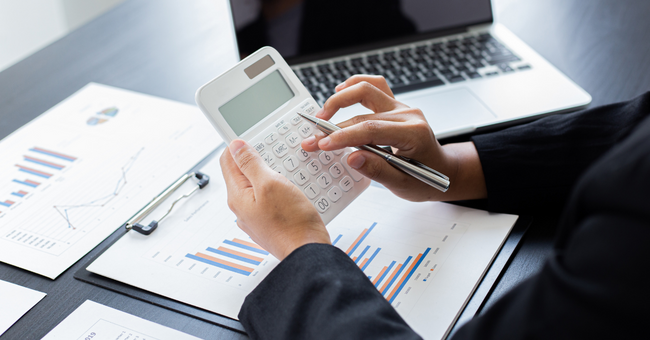 Homem sentado em escritório digitando em uma calculadora científica